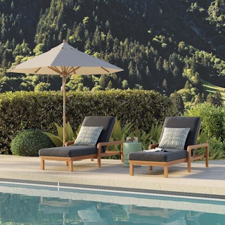 A stylish patio with black wicker chairs, a sofa, and a large umbrella.