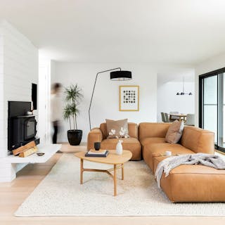A bright living room with a tan leather modular sectional