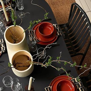 Moody dining table styled with the Sarek Outdoor Stackable Dining Chair in Black. Photo by @abhishekdekate