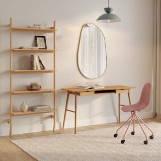 A modern home office with a wooden table, mixed chairs, and natural lighting.