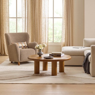 Bright living room sitting area, featuring the Adel 42" Round Coffee Table in Smoked Oak