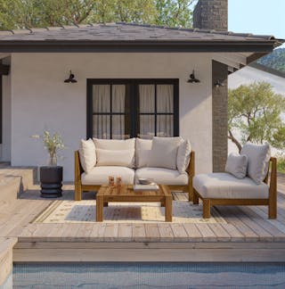 Sunny patio with greenery, featuring the Cove 68.5" Outdoor Modular Loveseat in Basket Gray