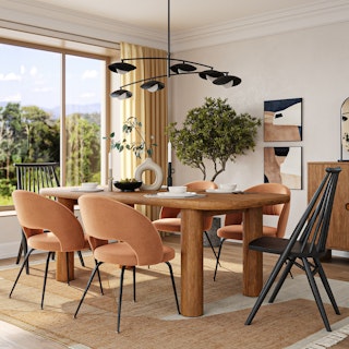 A modern dining room with a wooden table, mixed chairs, and bold lighting.