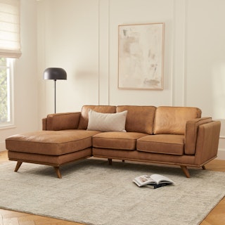 A brown leather sectional sofa with a left chaise in a cozy living room.