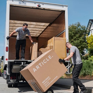 Two delivery drivers removing an Article box from a truck
