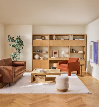 Kouva Modular Wall Desk and Kouva Modular Bookcase in natural oak with vertical wood detailing, styled in a neutral living room. 