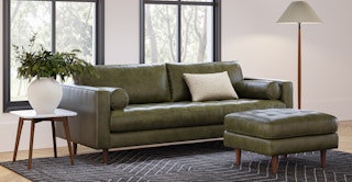 Warm mid-century modern living room featuring the Sven 88" Tufted Leather Sofa and Ottoman in Charme Green