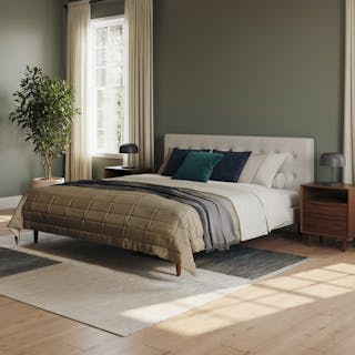 A cozy bedroom with a tufted bed, earthy tones, and soft natural light.