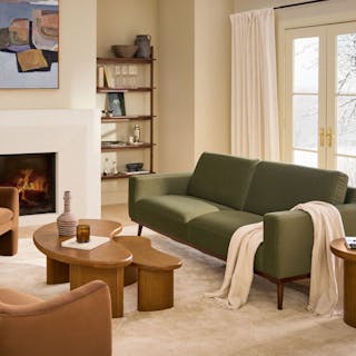 A green sofa in a warm, modern living room.